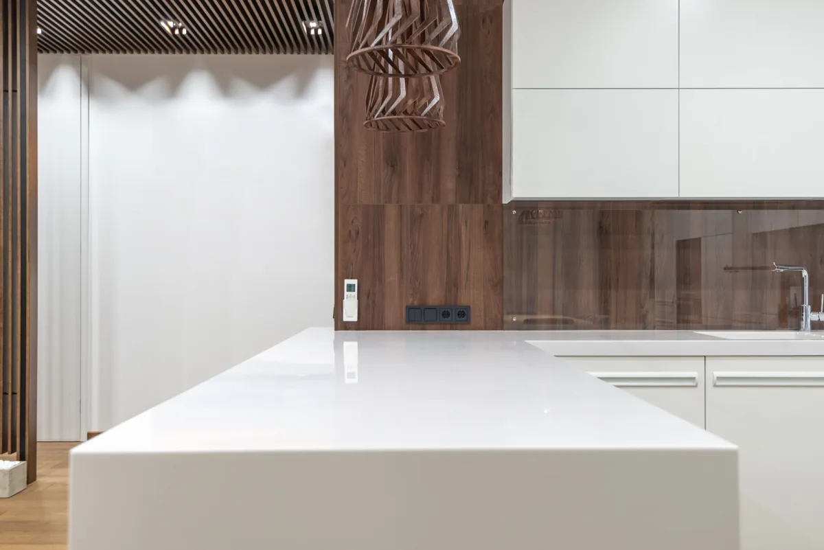 Clear white kitchen counters and warm wood cabinetry.